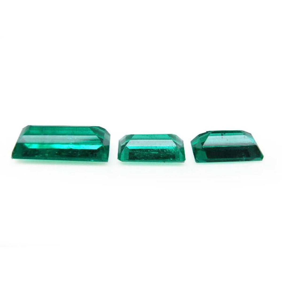 Matched trio set of baguette-cut natural Colombian emeralds with vibrant deep bluish-green color.