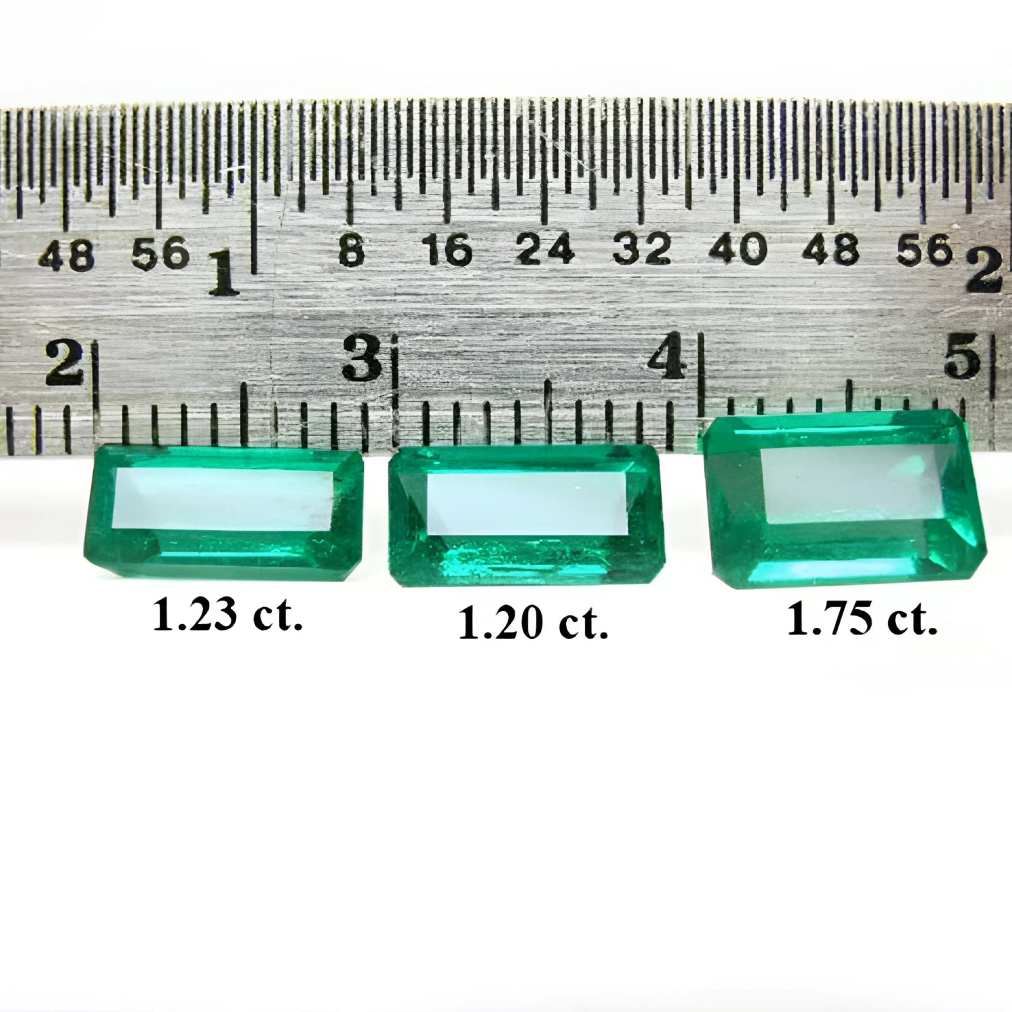 Three emerald-cut natural Colombian emeralds (1.23, 1.20, 1.75 ct) displayed with a ruler.