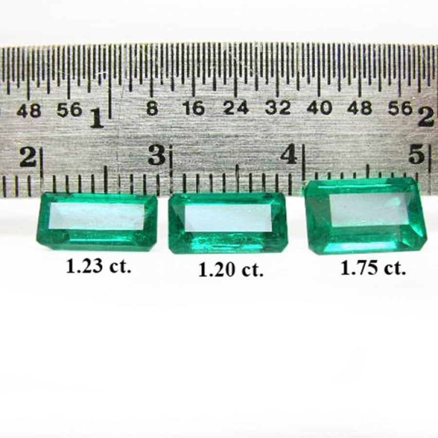 Three emerald-cut natural Colombian emeralds (1.23, 1.20, 1.75 ct) displayed with a ruler.