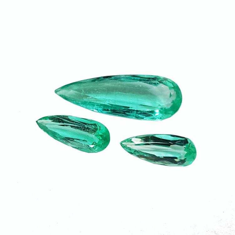 Three loose, pear-shaped Colombian emeralds with sparkling medium light green color.