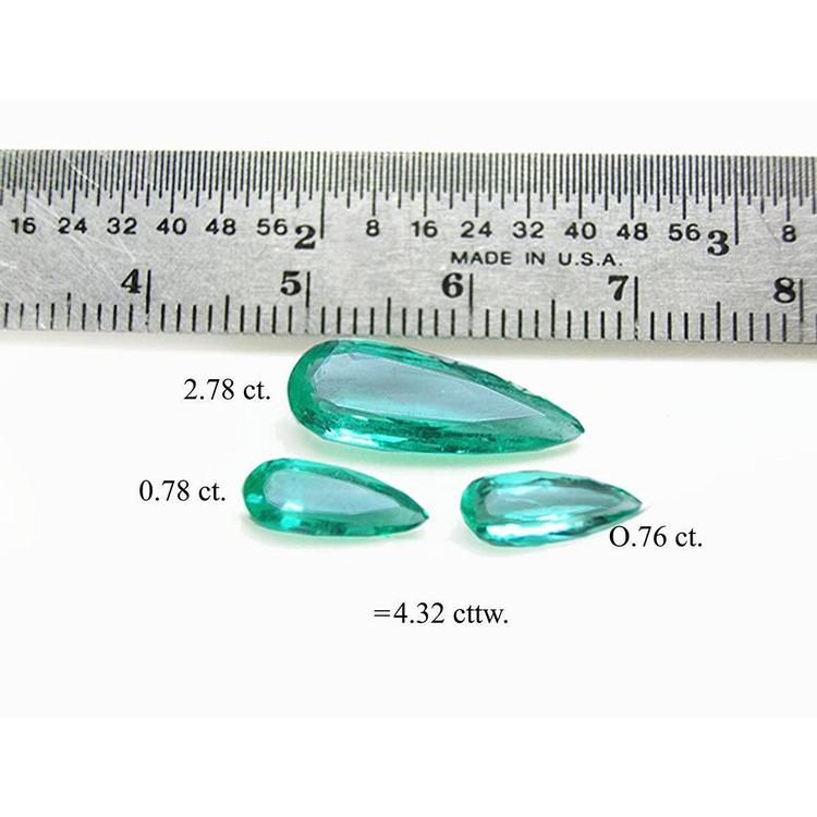 4.32 ct pear-shaped Colombian emeralds in a matching set, shown with a ruler for scale.