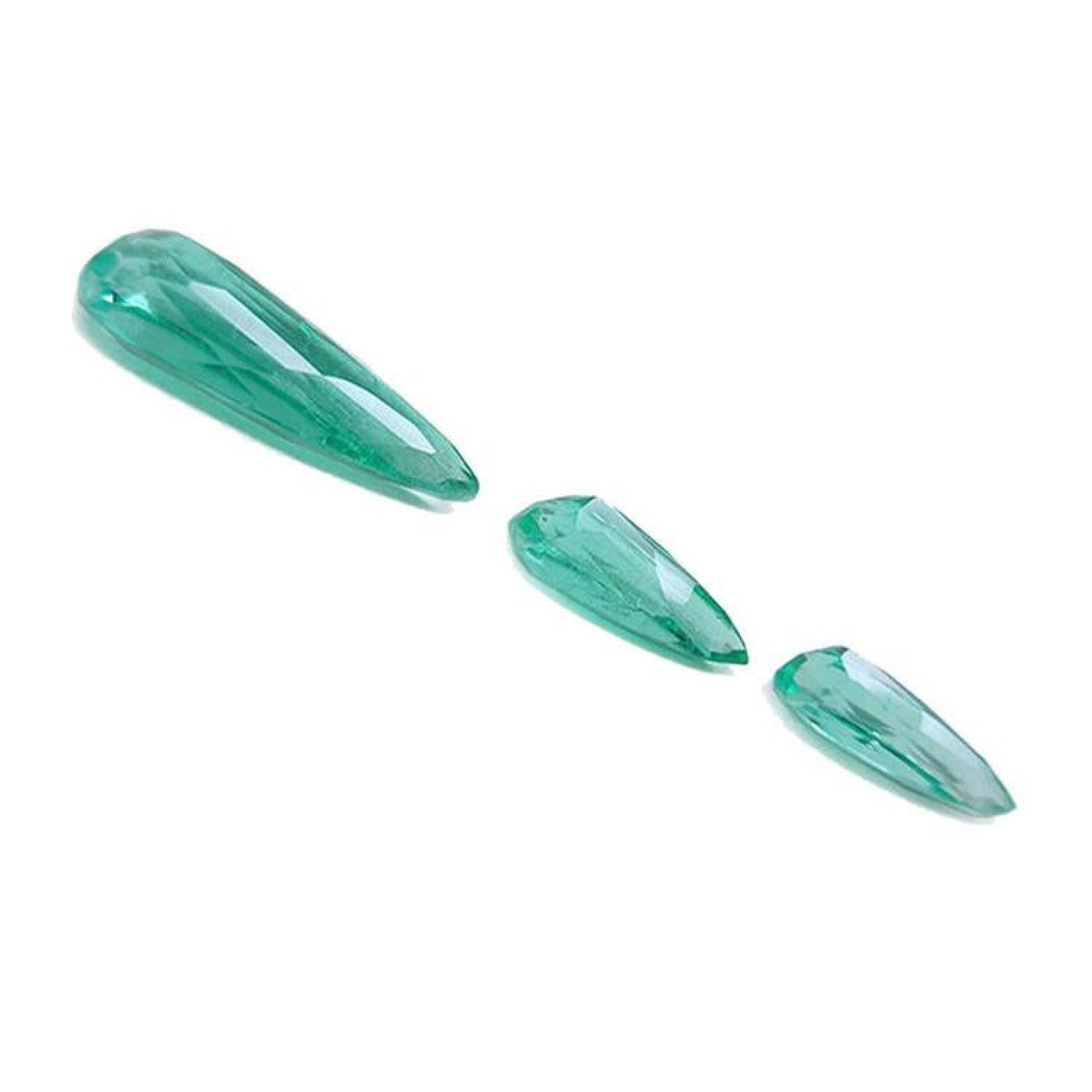 Three sparkling pear-shaped Colombian emeralds, one large and two smaller, on a white background.