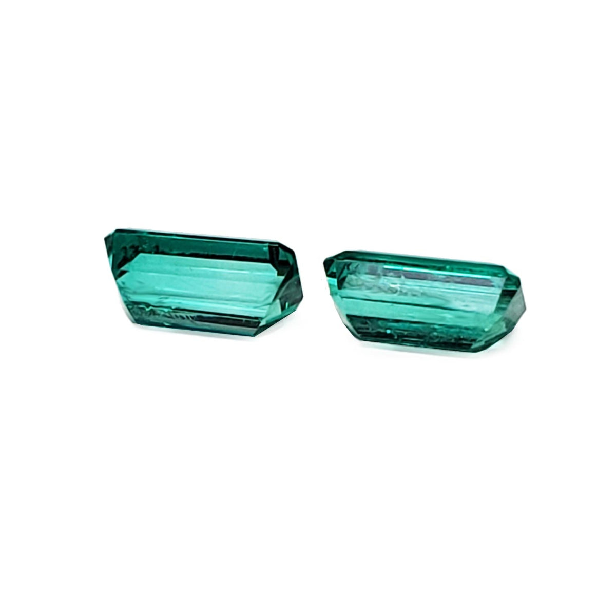 Emerald-cut matching pair loose emeralds from Muzo Colombia, underside view girdles and pavilions visibles