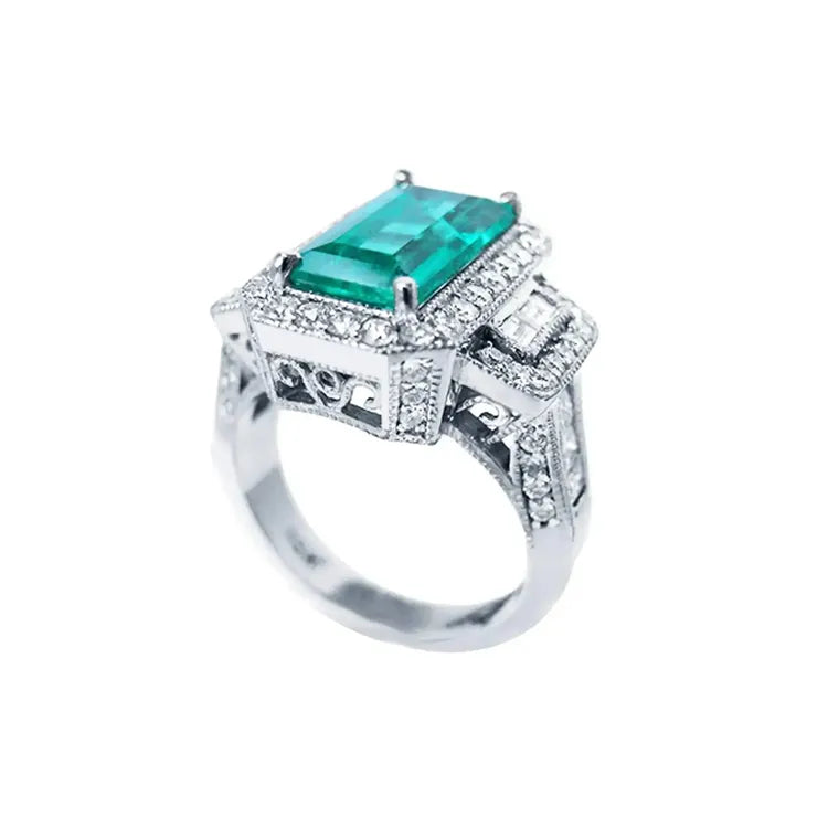 Anillo de compromiso de oro blanco 18k con esmeralda colombiana rectangular de 2.99 ct y diamantes.