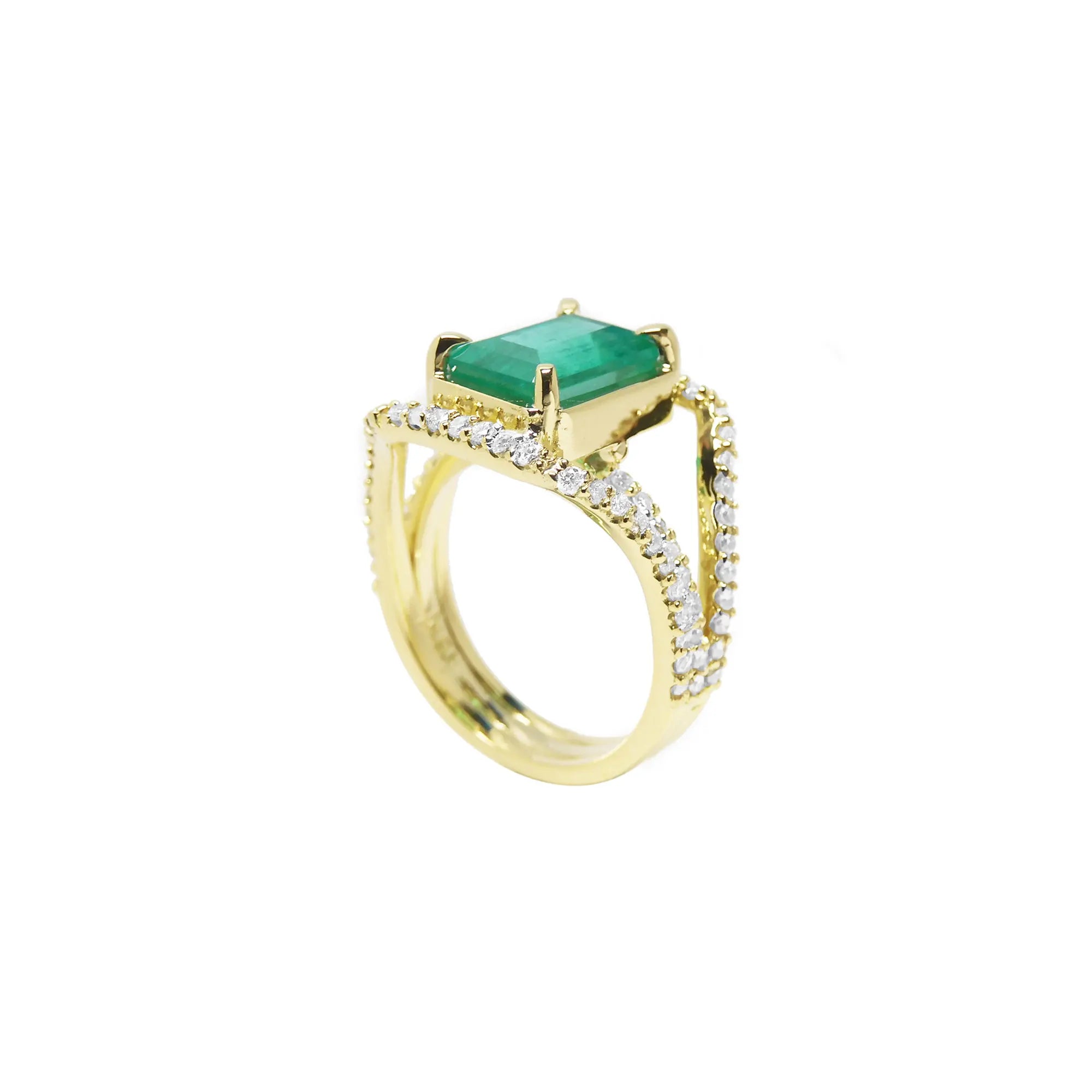 En perfil de medio lado este anillo para mujer muestra la esmeralda en la parte superior de tres aros con diamantes.