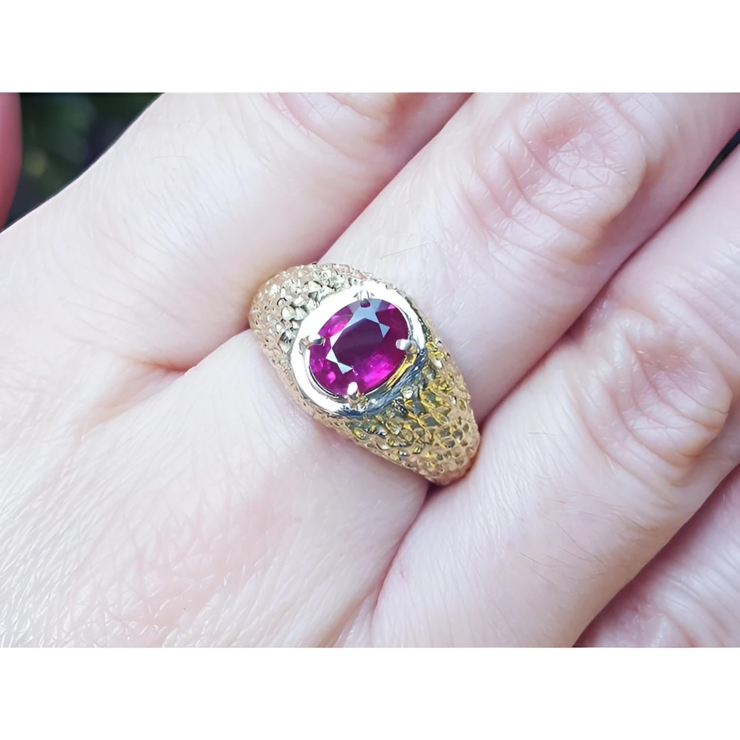 Men's 18K yellow gold ring with a sparkling oval-cut pinkish-red Burma ruby solitaire.