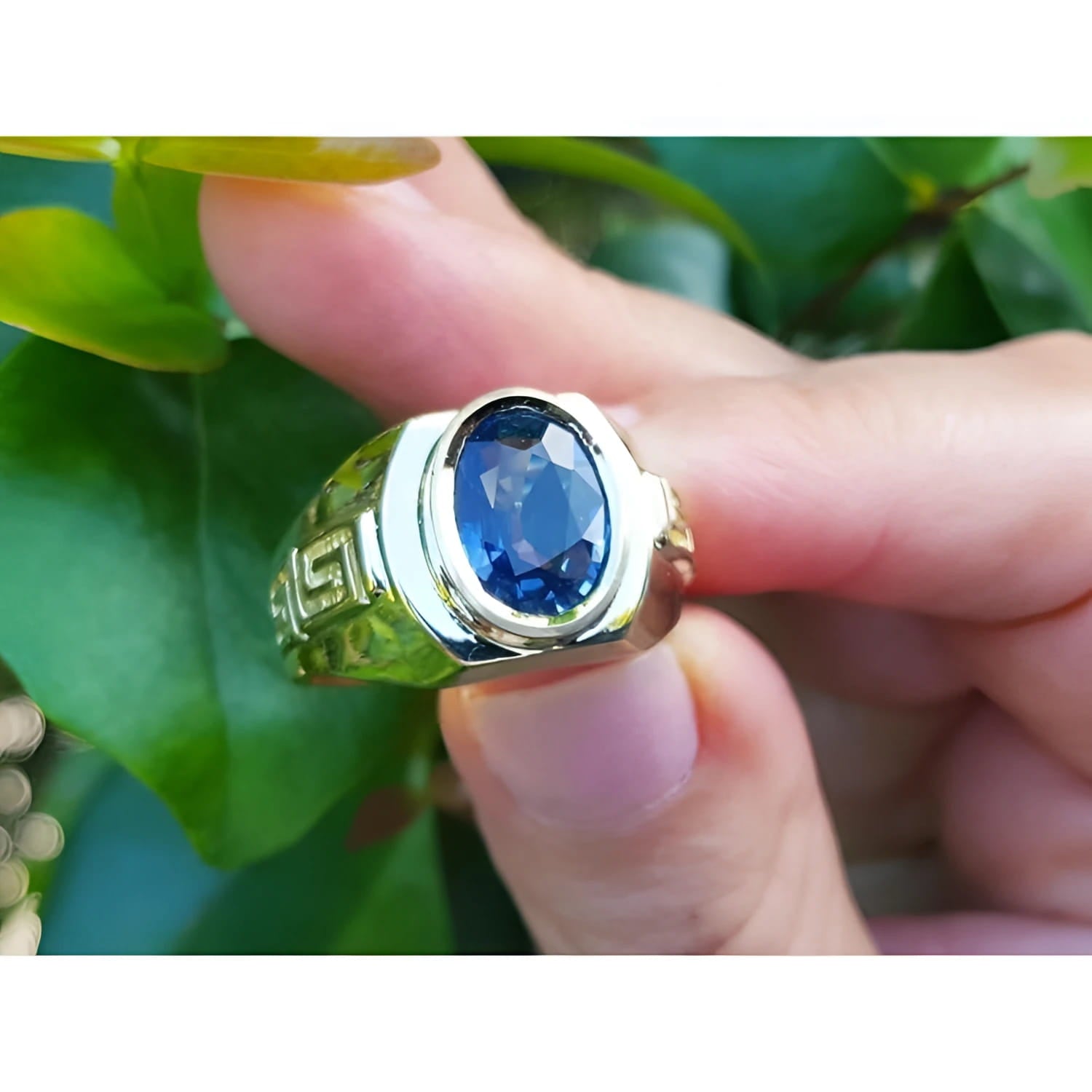 Men's genuine blue sapphire solitaire ring oval cut, with a medium-dark blue hue, that highlights its brilliance and clarity.