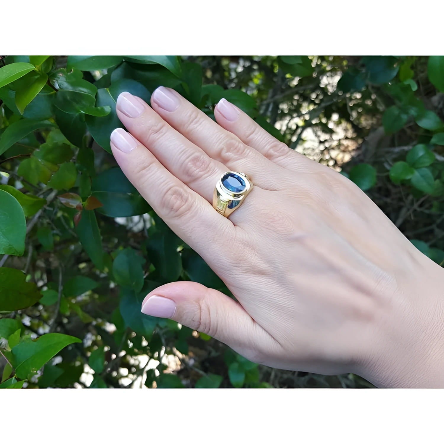 Men's 18K yellow gold ring with an oval blue sapphire and Greek key design.