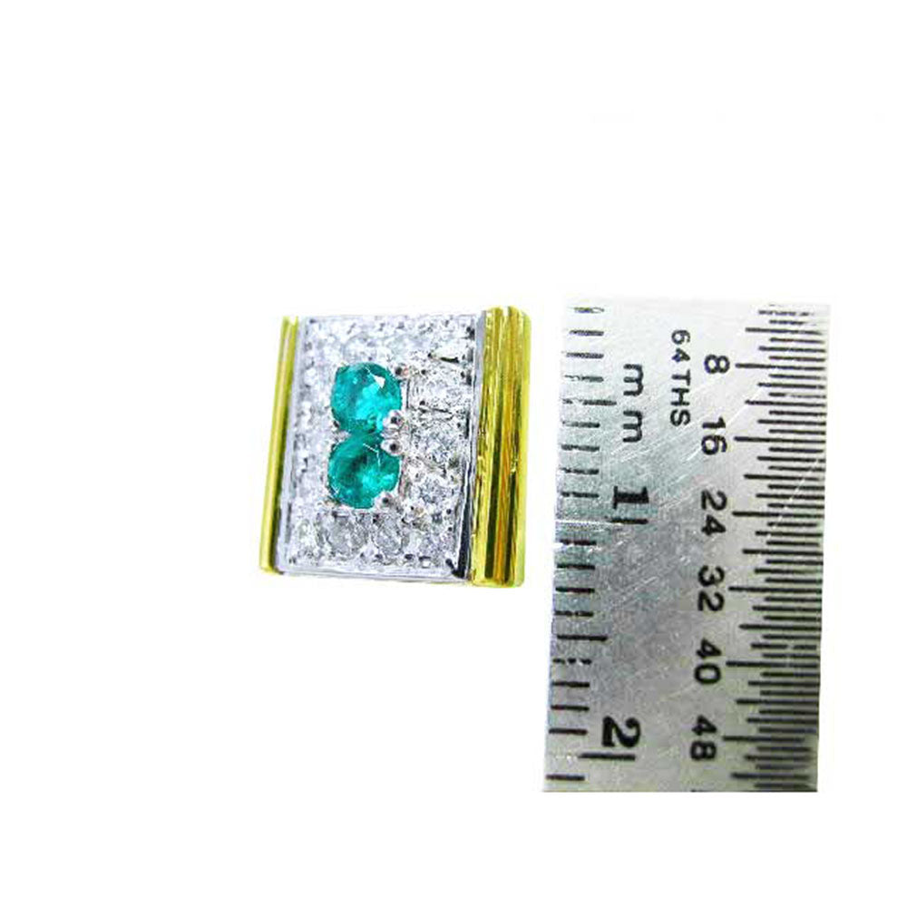 A yellow and white gold cufflink for men next to a ruler for scale on a white background.