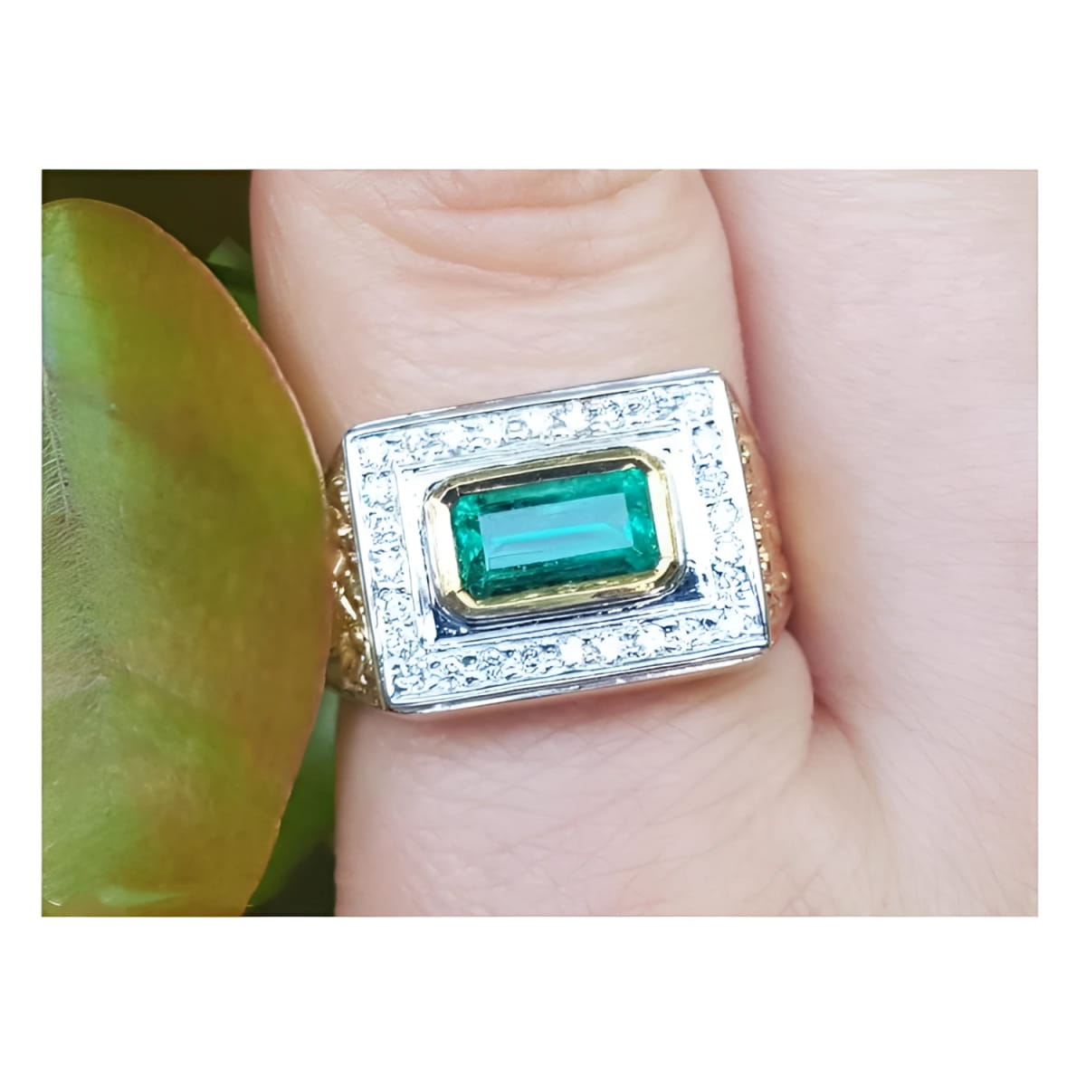 A 14k yellow gold men’s ring featuring a bezel-set natural Colombian emerald and sparkling diamonds, worn on a finger.