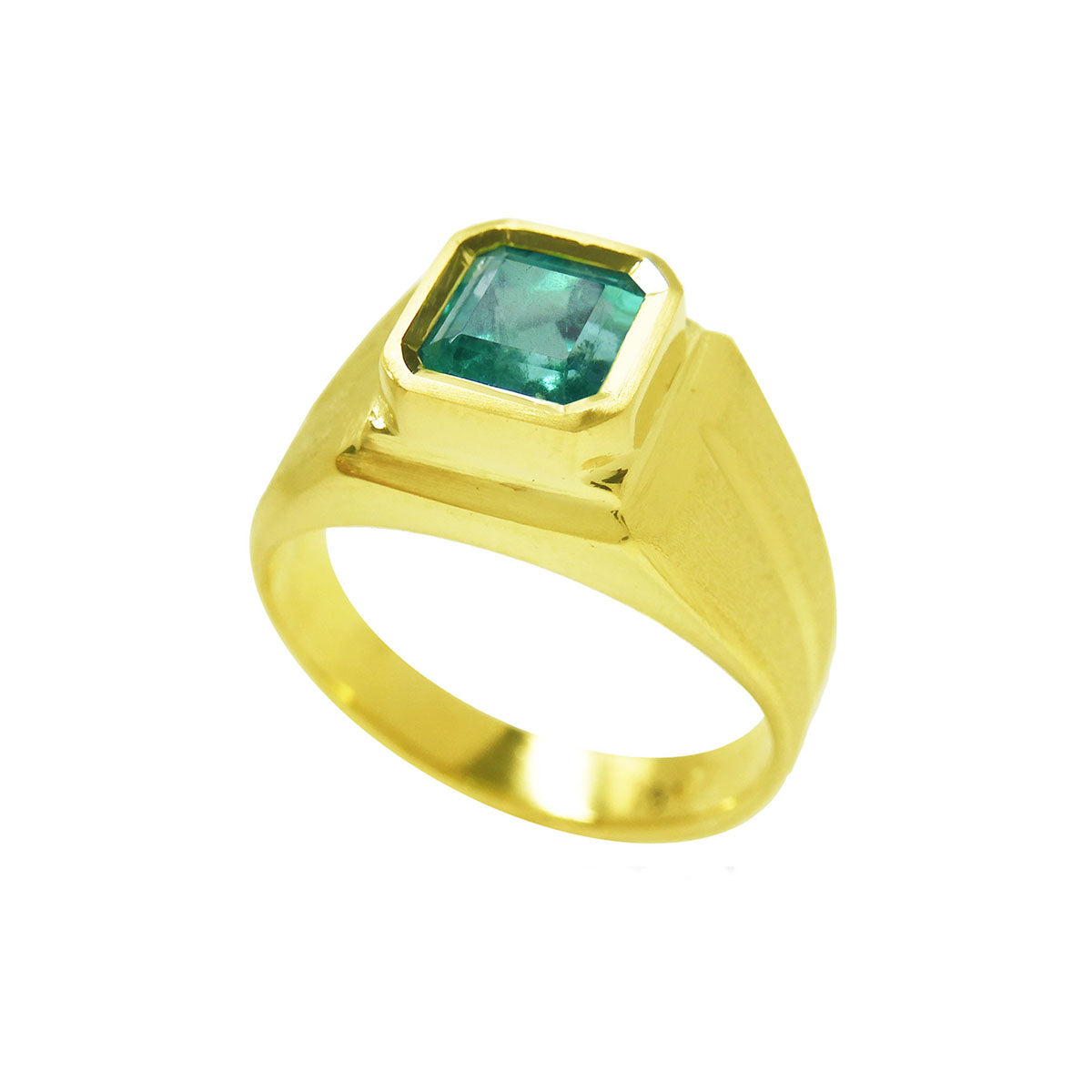 A yellow gold emerald pinky ring for man displaying its top bezel set and partial sides perspective.