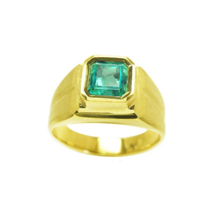 Gold emerald pinky ring for men on a white background.