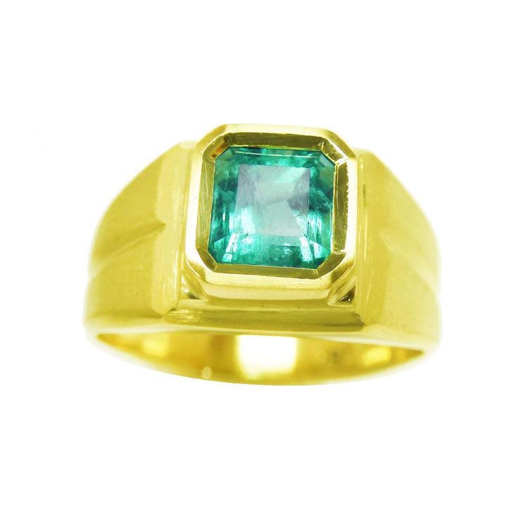 A men's emerald pinky ring in yellow gold displaying its top and side profile.