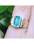 This men’s ring features a bezel-set emerald, accented with natural diamonds, and crafted from 14k yellow gold.
