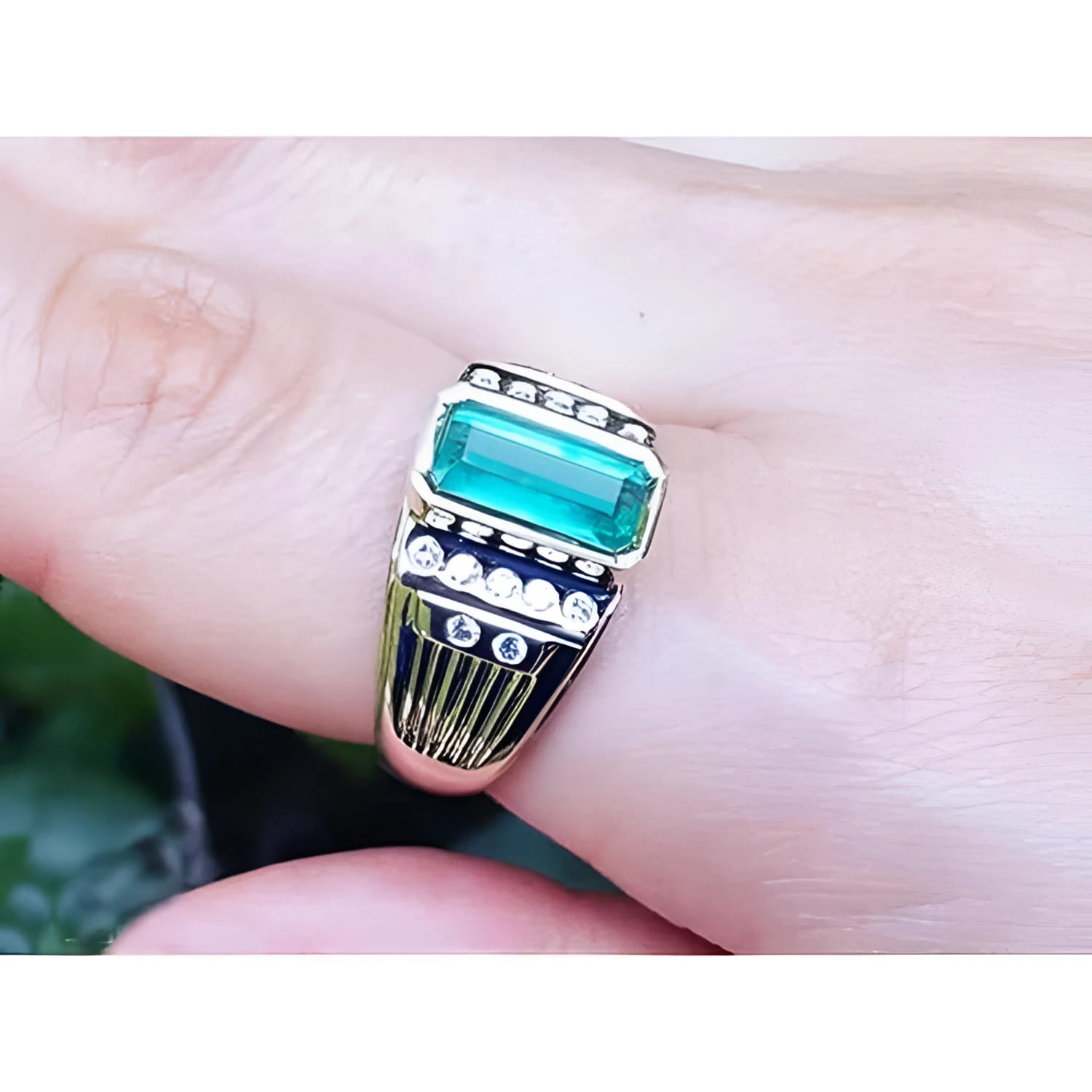 Men's 14K yellow gold ring with a rectangular Colombian emerald and burnish-set diamonds.