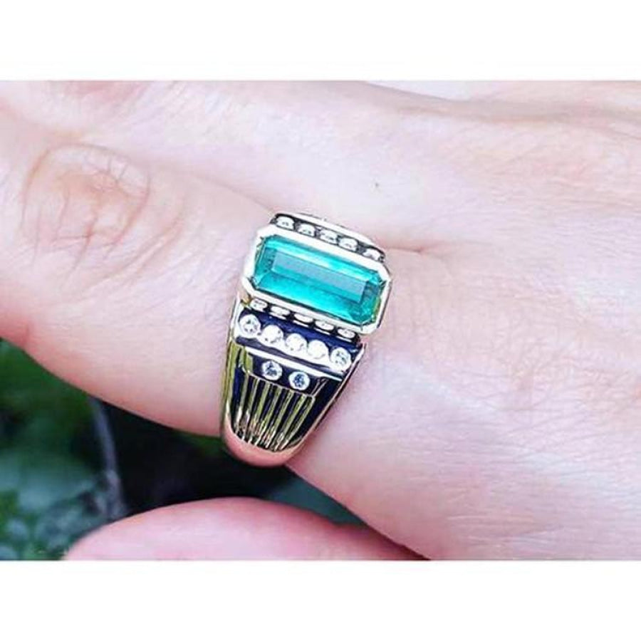 Men's 14K yellow gold ring with a rectangular Colombian emerald and burnish-set diamonds.