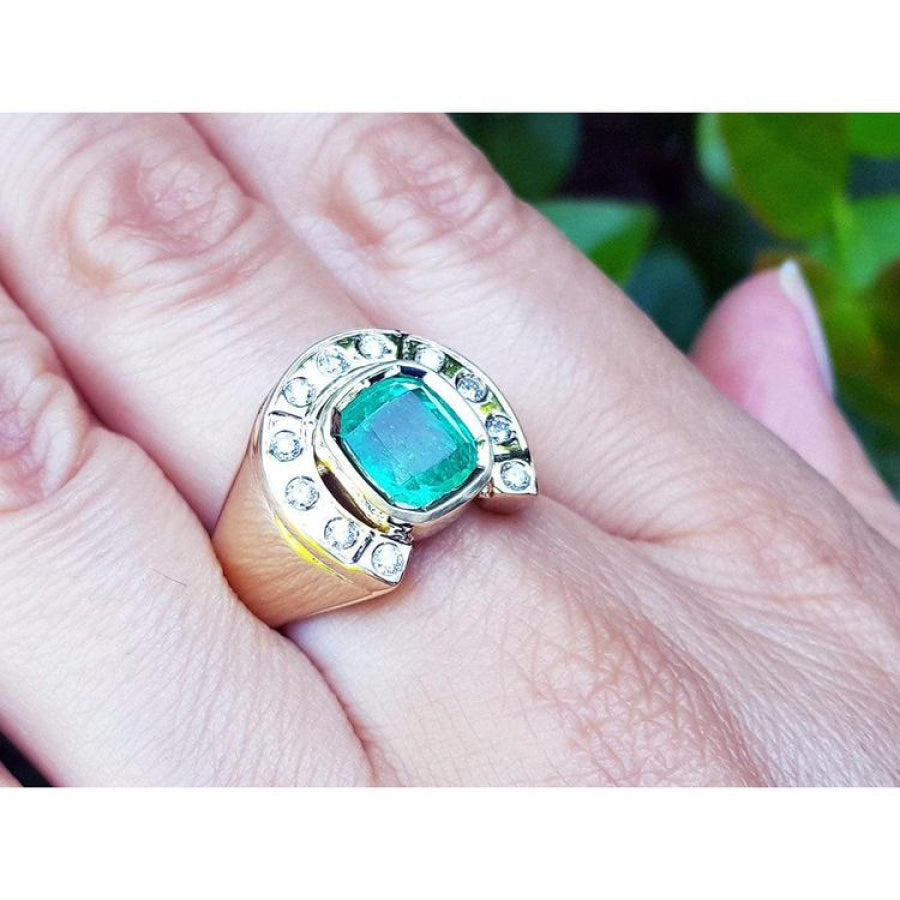Men's 14K yellow gold horseshoe ring with a cushion-cut emerald and burnish-set diamonds.