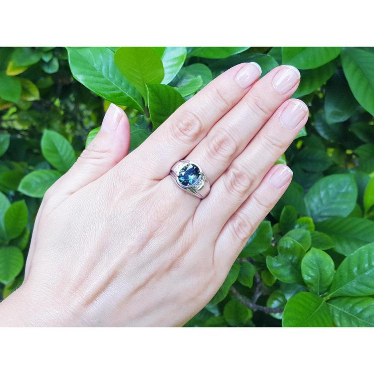 Men's 14K white gold ring with a deep greenish-blue oval cut Australian sapphire and diamond accents.
