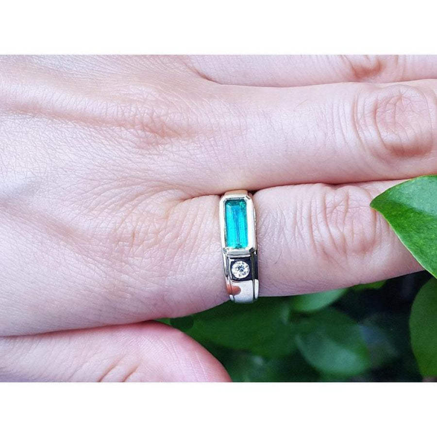 Men's 14K yellow gold ring with a deep green elongated emerald and burnish set side diamond.