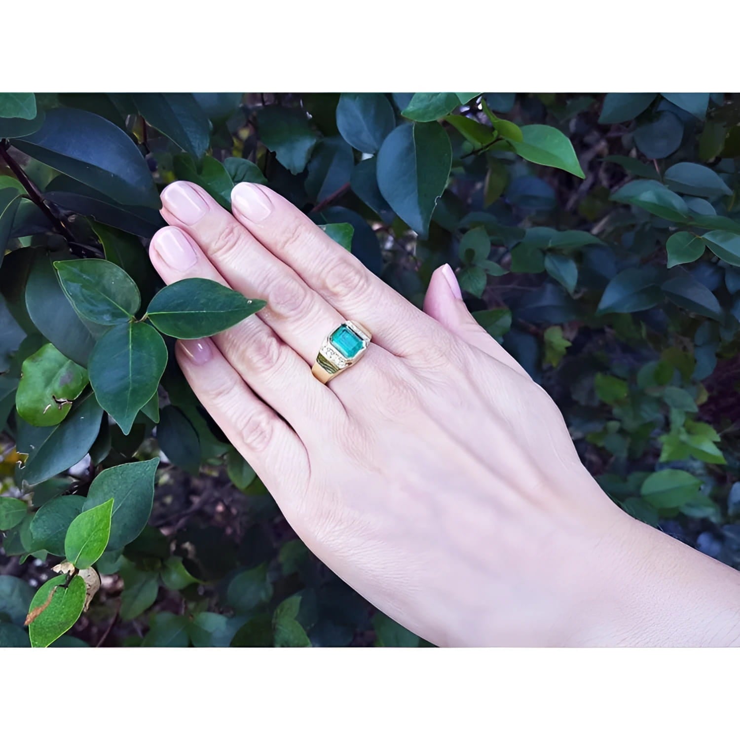 Men's 18K yellow gold ring with a rectangular 2.90 ct. Colombian emerald and diamond accents on a hand.