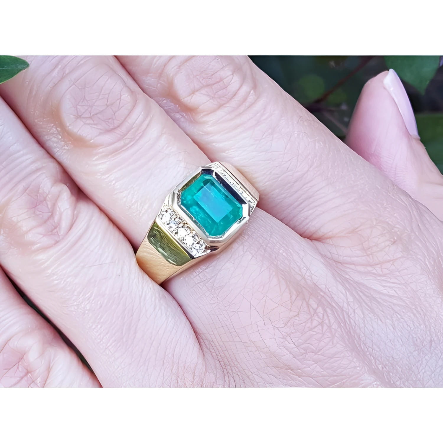 Men's 18K yellow gold ring with a rectangular 2.90 ct Colombian emerald and diamond accents on a hand.