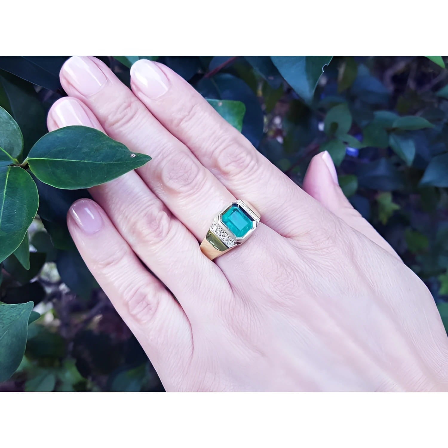 Men's 18K yellow gold ring with a 2.90 ct. Colombian emerald and diamond accents on a hand.