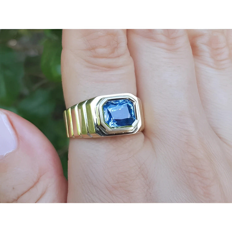 A 18k gold ring with a blue natural blue sapphire gemstone GIA certified bezel set in an east-west orientation.