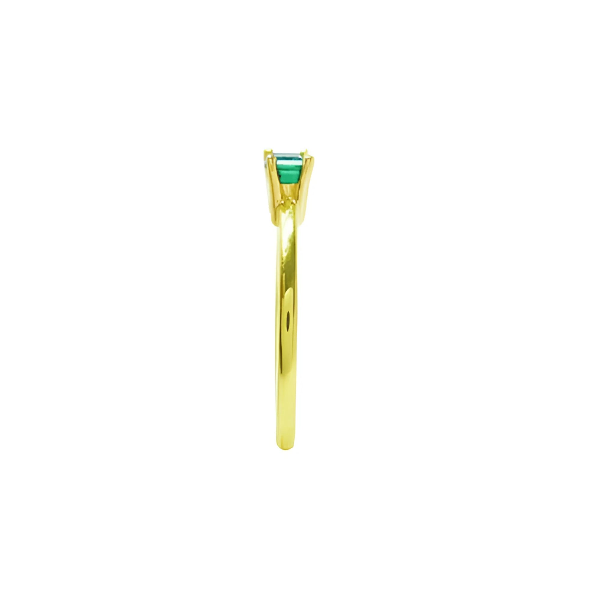 Minimalist 14K yellow gold ring with a prong-set, east-west oriented emerald solitaire.
