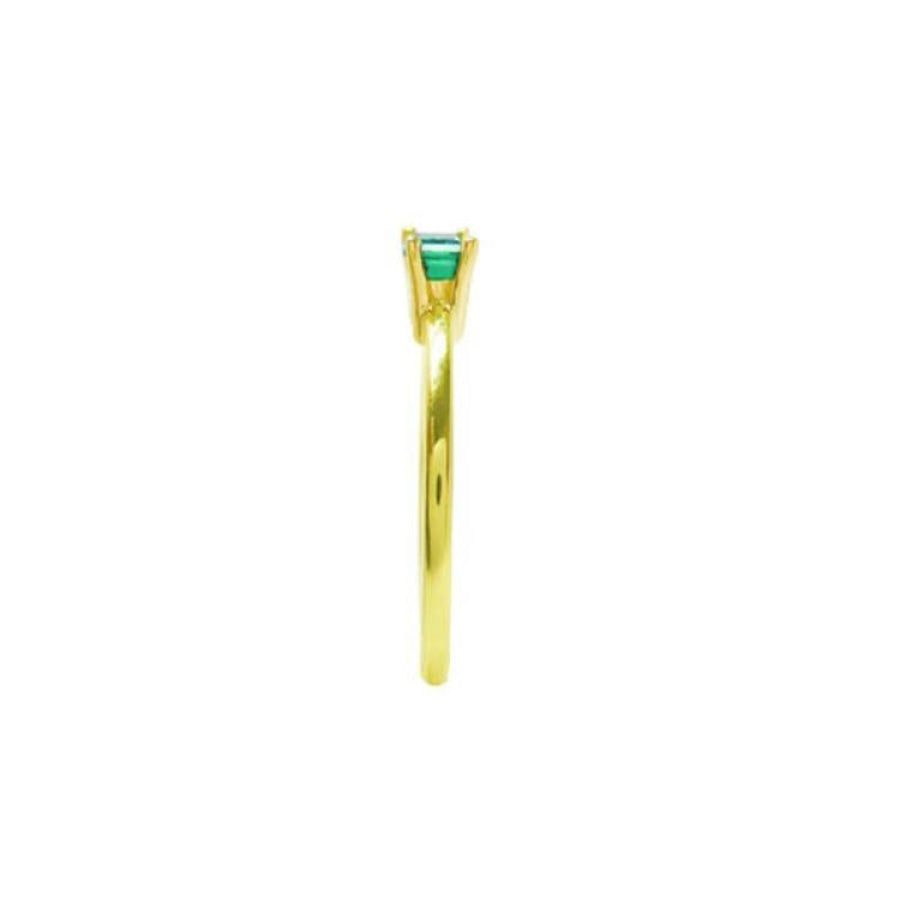 Minimalist 14K yellow gold ring with a prong-set, east-west oriented emerald solitaire.
