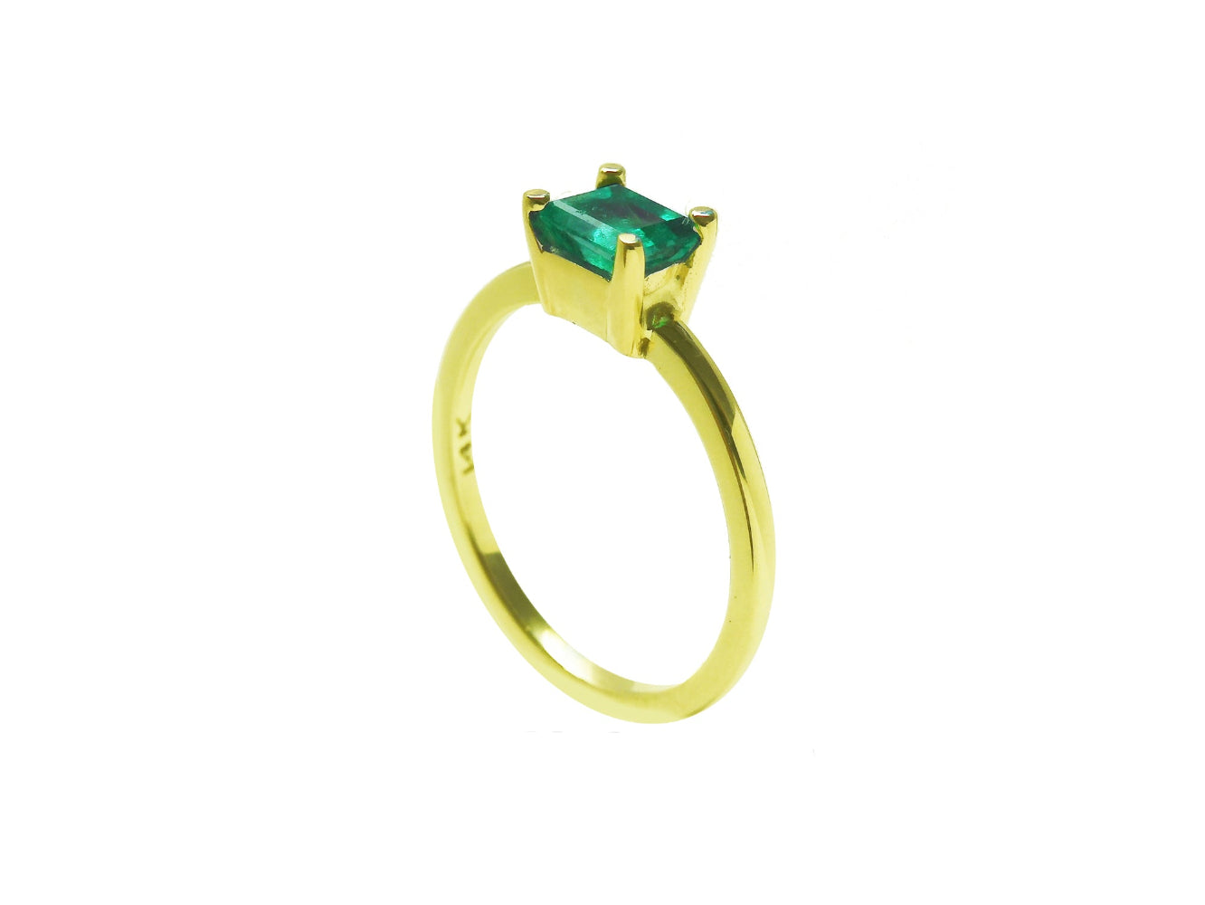 The side profile perspective of a minimalist emerald solitaire ring representing May&#39;s birthstone jewelry.
