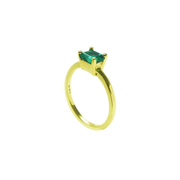 The side profile perspective of a minimalist emerald solitaire ring representing May's birthstone jewelry.