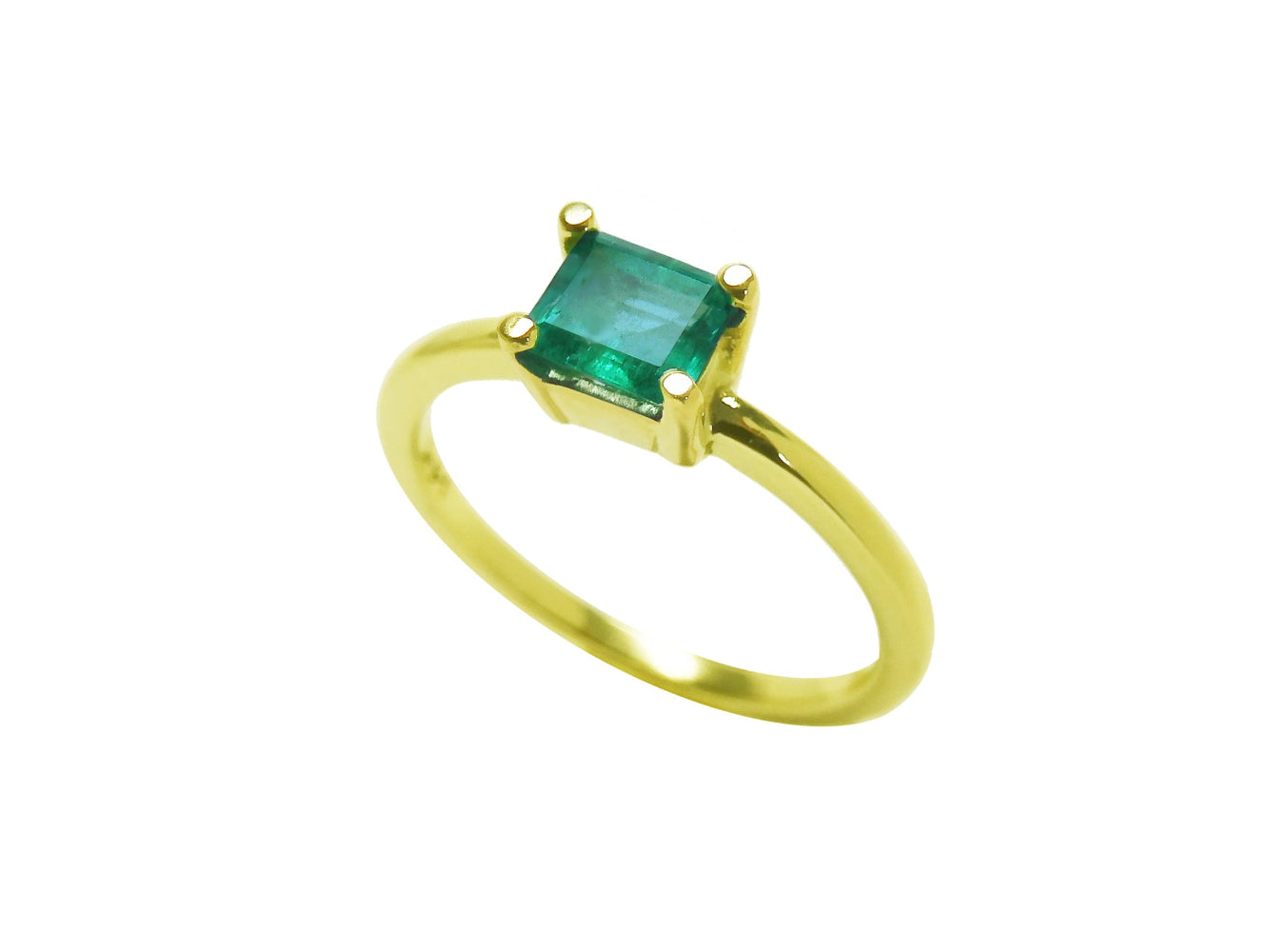 Tilted position for this minimalist emerald solitaire ring representing May's birthstone jewelry, topside and band ring profile visibles.