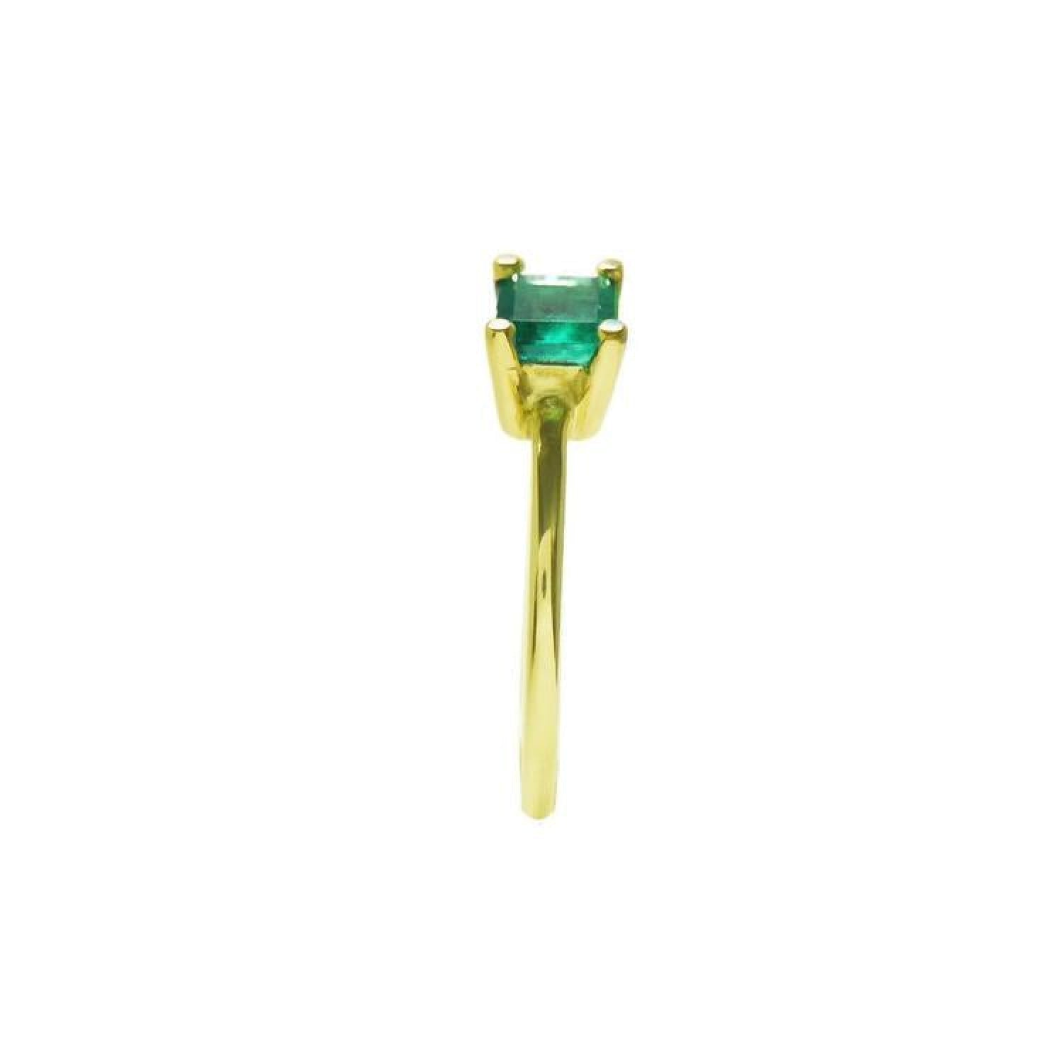 Minimalist 14K yellow gold ring with a petite, prong-set emerald solitaire.