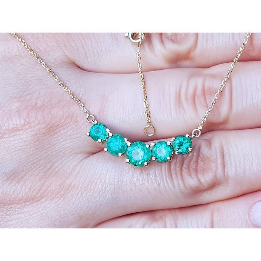 14K gold necklace with five round, medium green Colombian emeralds in elegant basket settings.