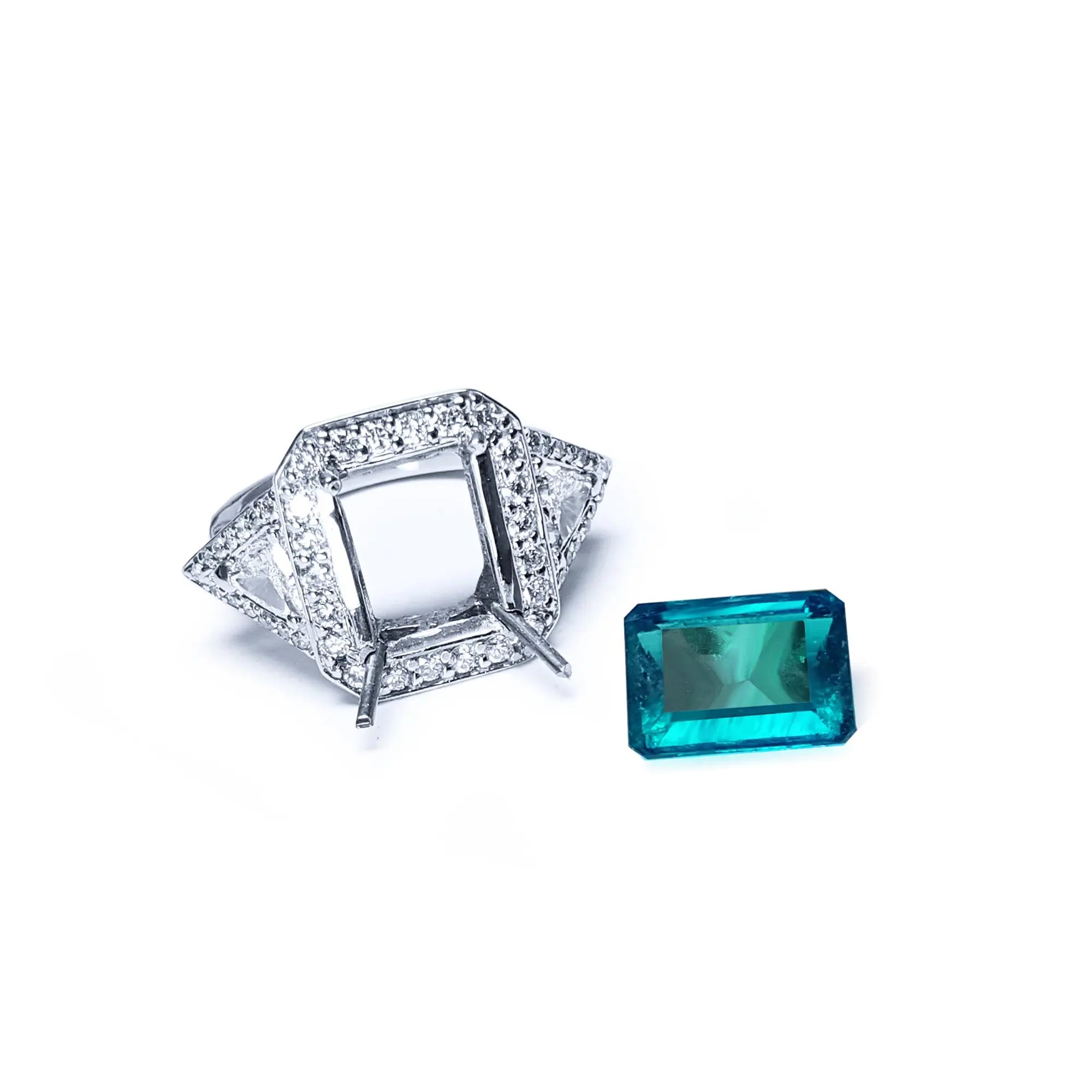 Montura de anillo para dama en oro blanco y diamantes con la esmeralda que se va a engastar a un lado.