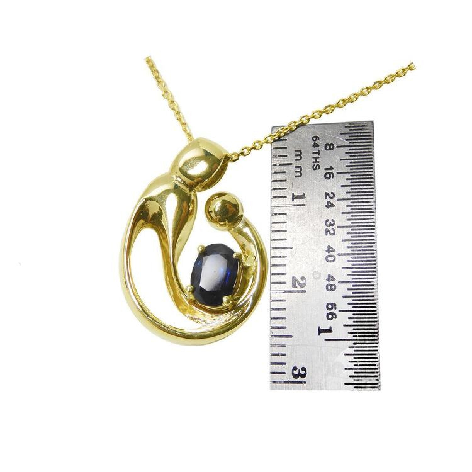 14K yellow gold mother and child pendant with an oval blue sapphire, shown with a ruler.