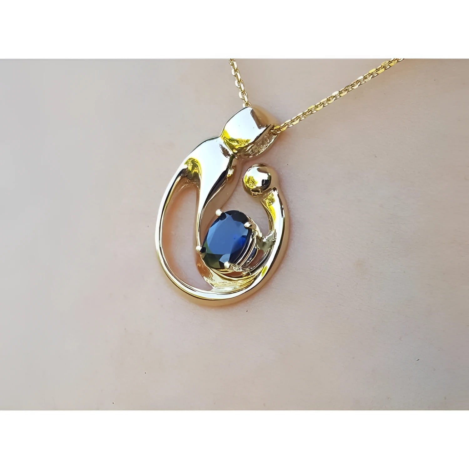 Displaying a gold pendant with a natural blue sapphire on a woman's collar neck