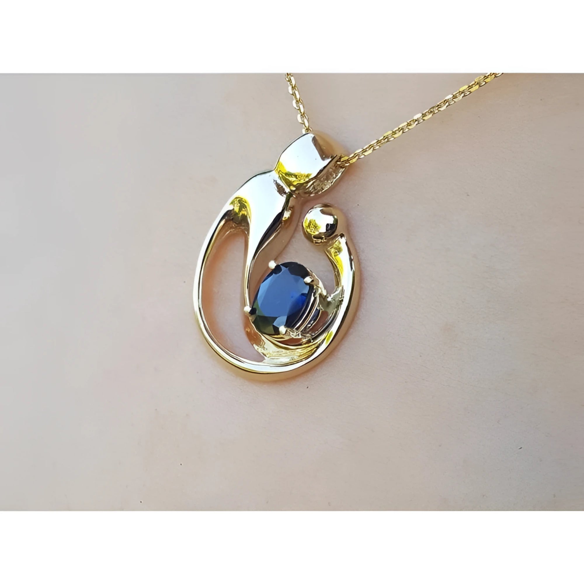 Displaying a gold pendant with a natural blue sapphire on a woman's collar neck