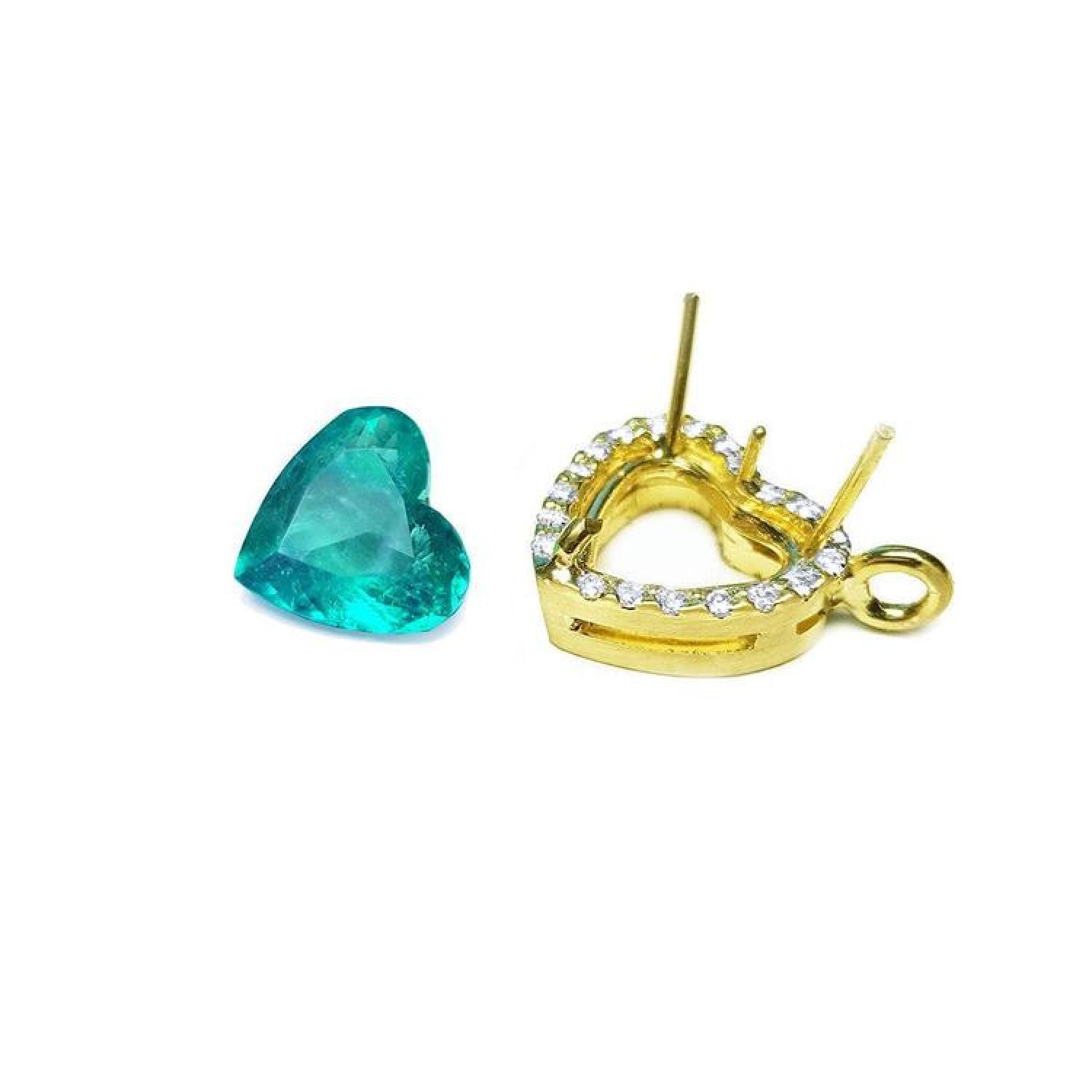 Heart-shaped Colombian emerald next to an 18K yellow gold halo diamond pendant setting.