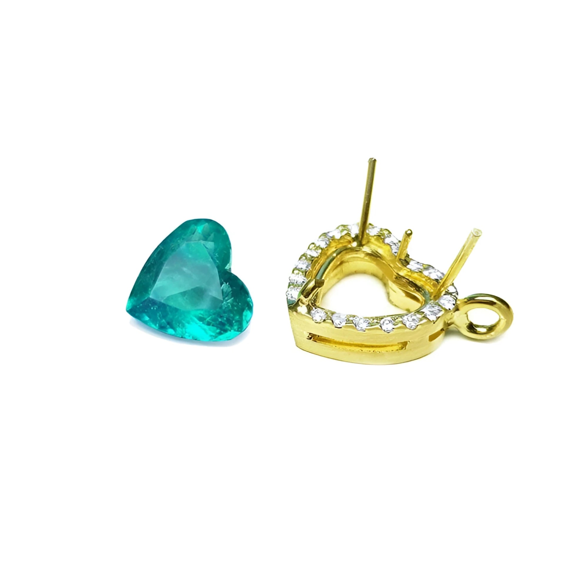 Heart-shaped Colombian emerald next to an 18K yellow gold halo diamond pendant setting.
