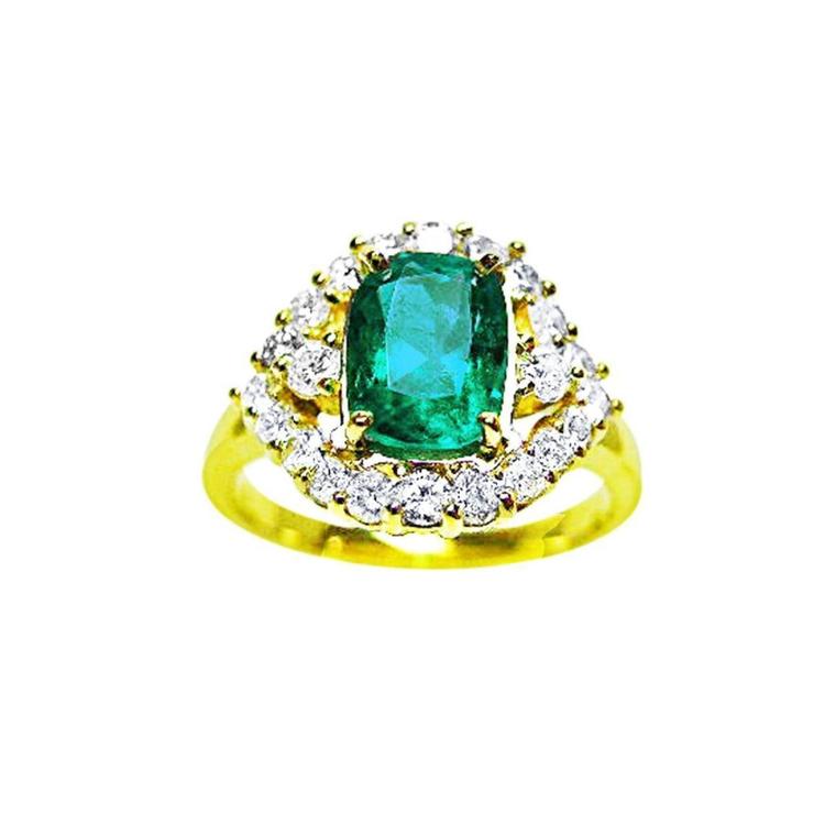 A 14K yellow gold ring featuring a Muzo Colombian emerald surrounded by a halo of diamonds, showcased from a topside perspective.