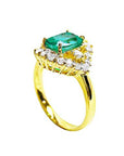 A cushion-cut Muzo Colombian emerald centerpiece ring encircled by diamonds, highlighting both the top view and the side profile of the band.