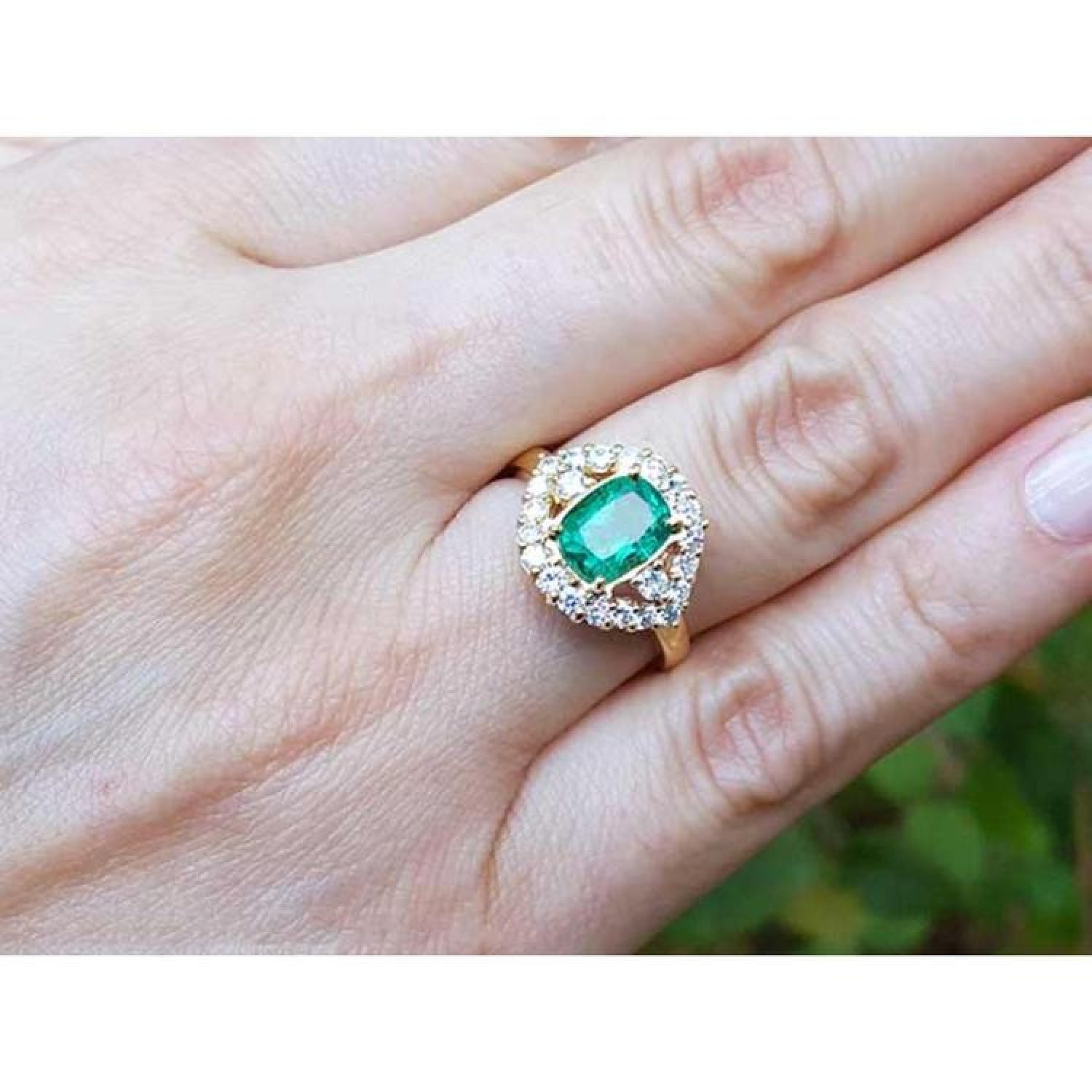 1.43 ct cushion-cut Muzo Colombian emerald ring with marquise diamond halo in 14K yellow gold.