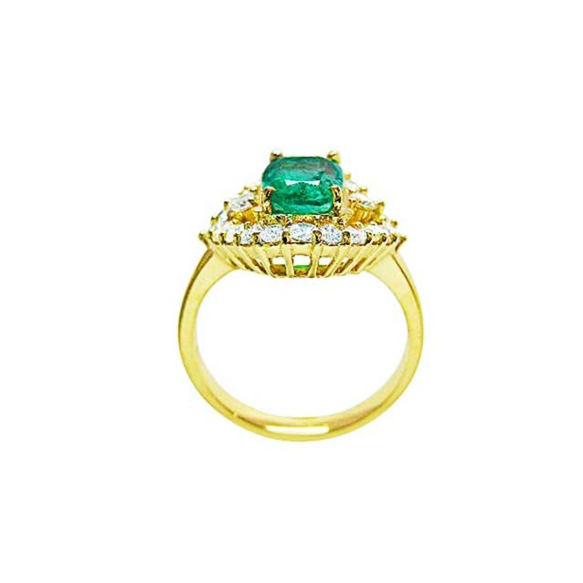 A yellow gold emerald ring displaying its lateral perspective fron the top setting. gallery and band ring.