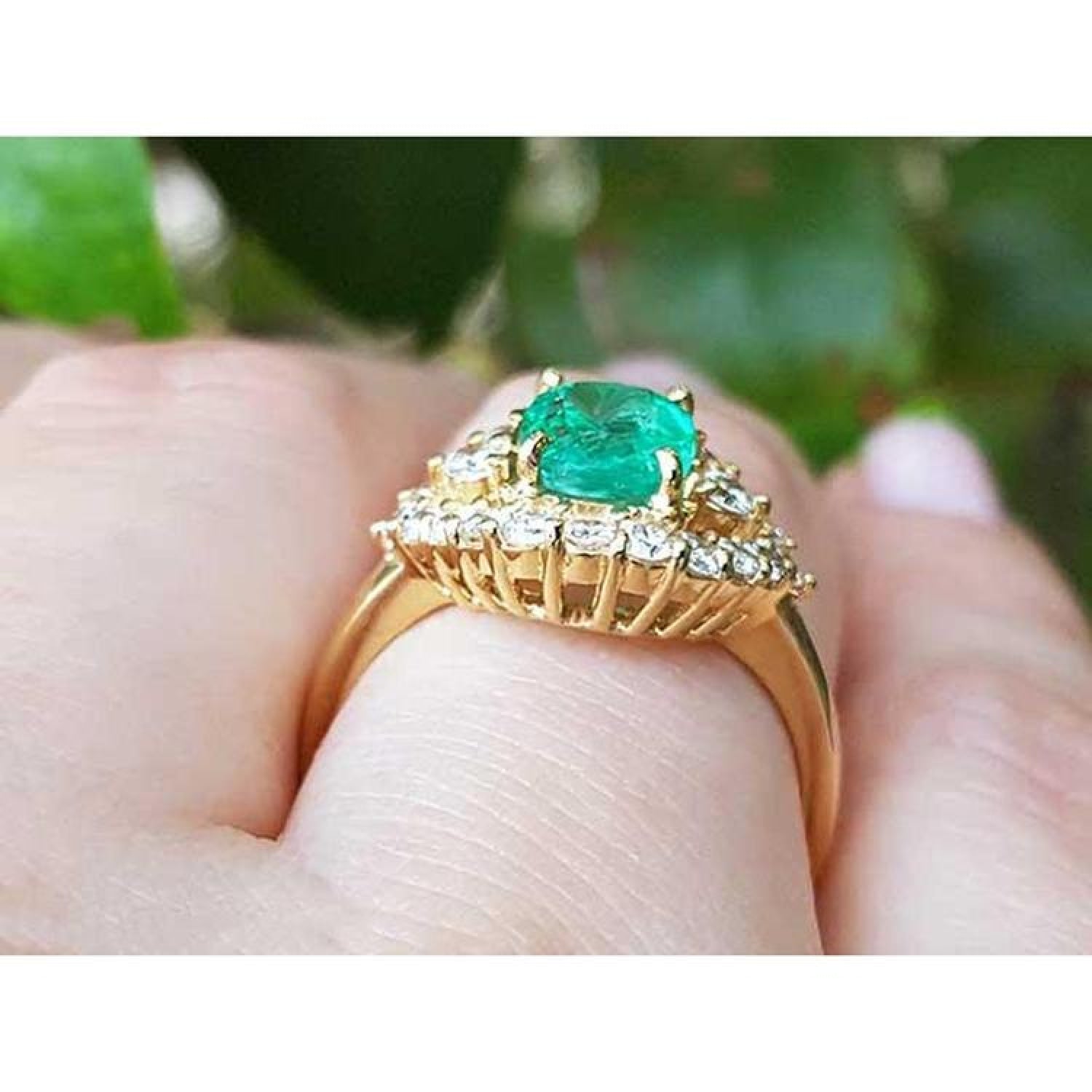 1.43 ct cushion-cut Muzo Colombian emerald ring with marquise diamond halo in 14K yellow gold.