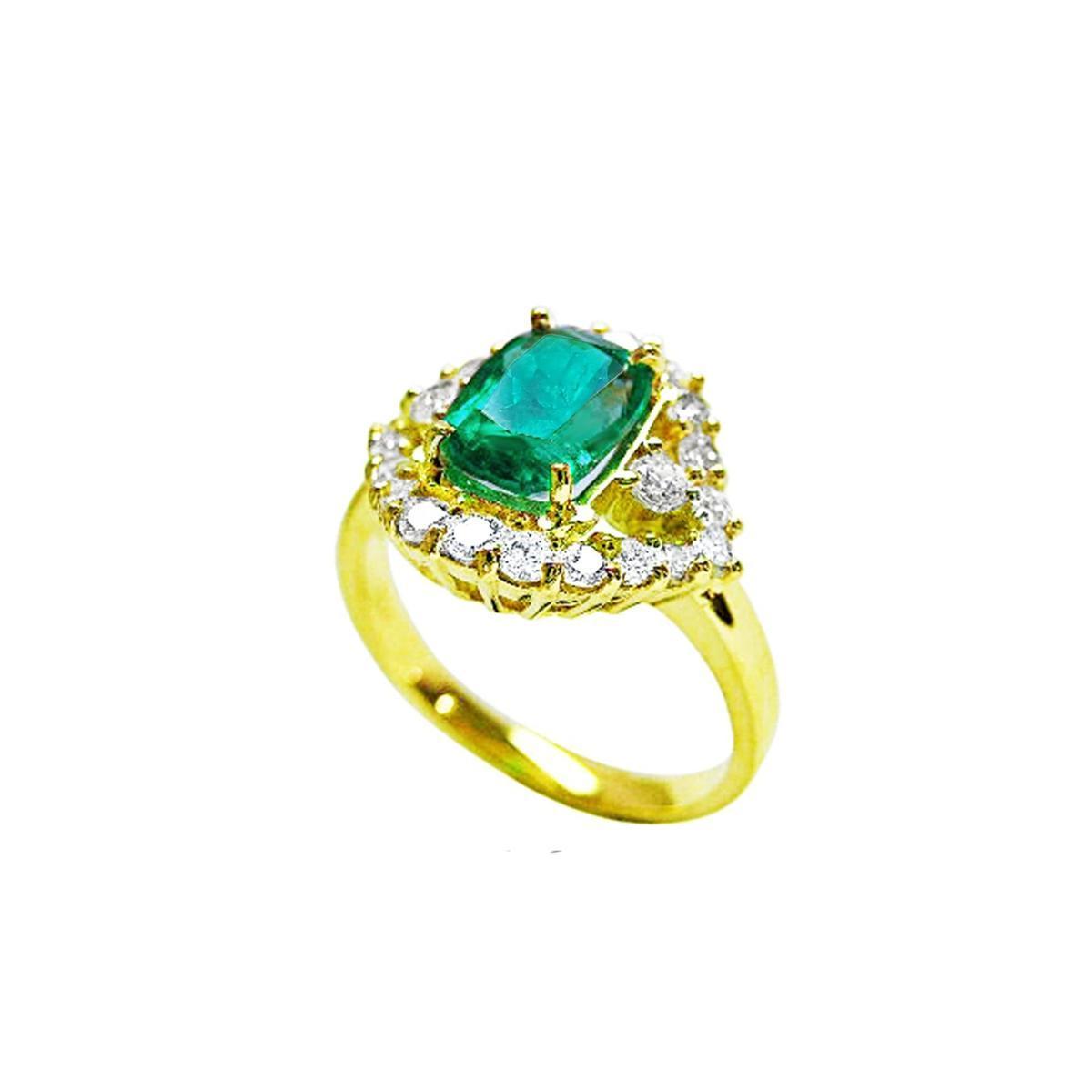 The side of this emerald ring shows the top cushion cut gemstone, the halo diamonds and band in yellow gold.
