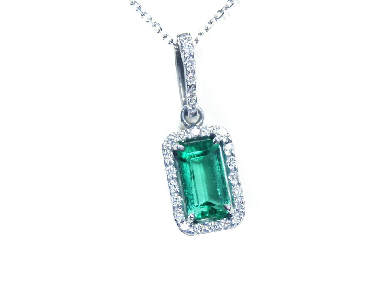Emerald-cut gemstone pendant with diamond accents on a white background