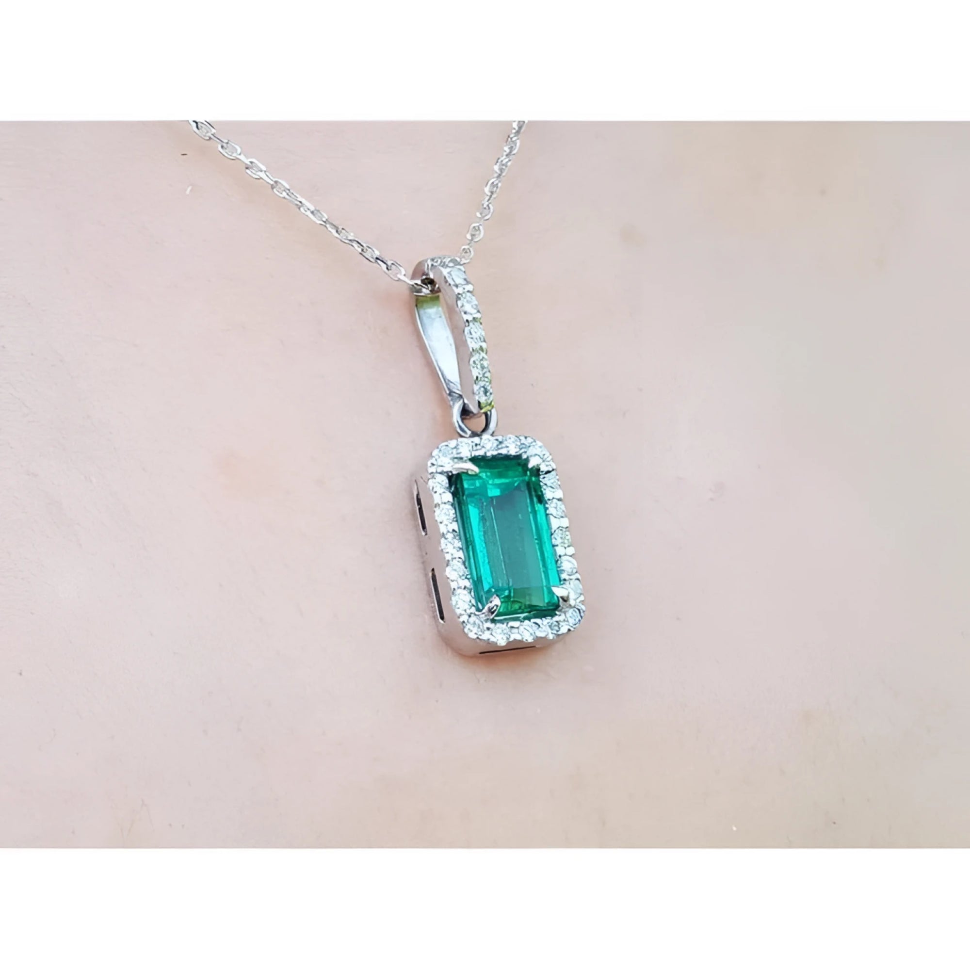 1.70 ct. Muzo Colombian emerald pendant with diamond halo on an 18K white gold chain.