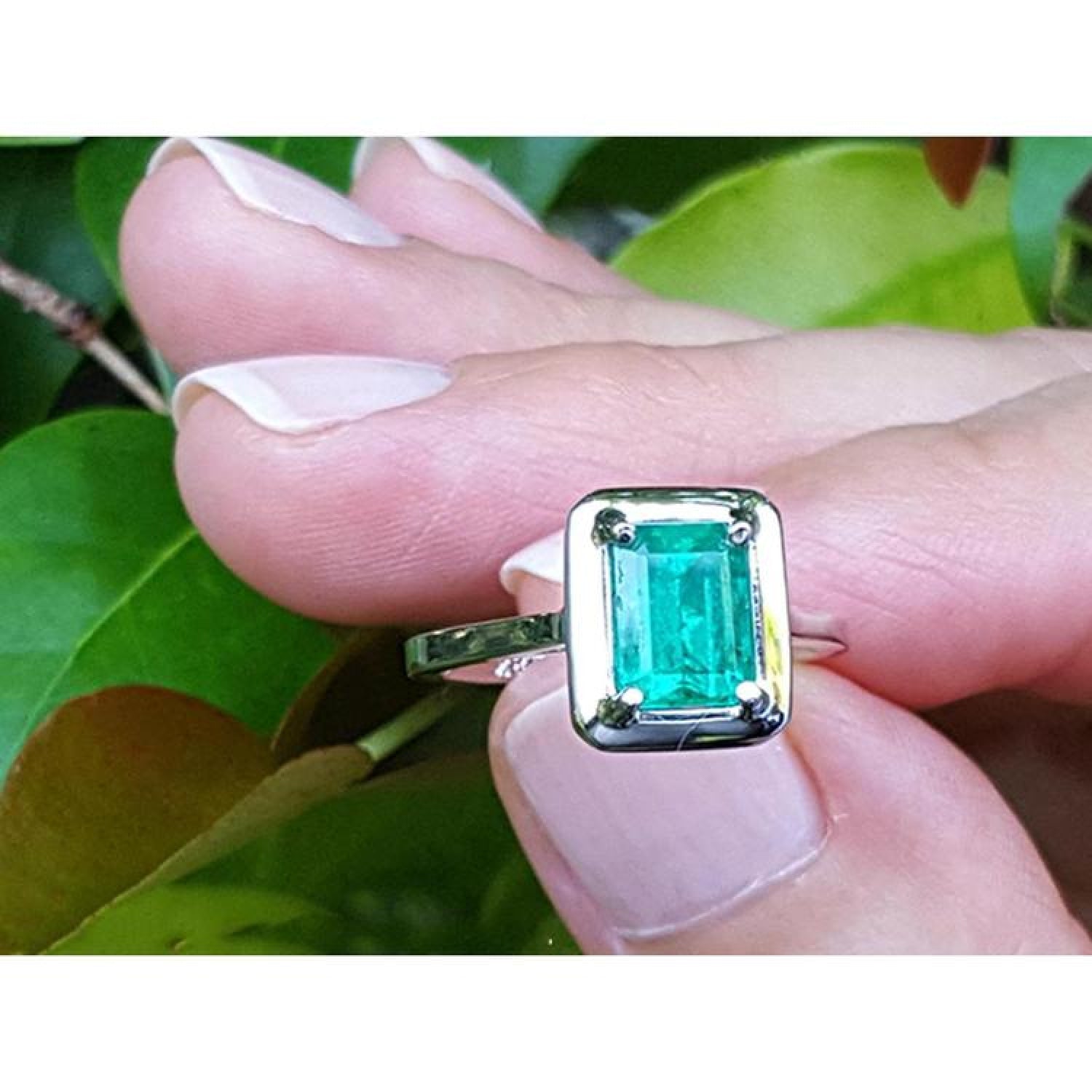 1.50 carat Muzo Colombian emerald solitaire ring in 18K white gold, rectangular cut, prong set.
