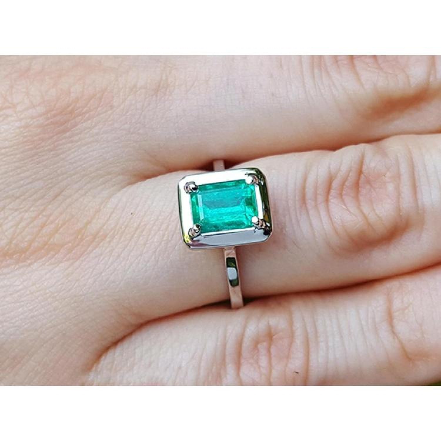 1.50 carat Muzo Colombian emerald solitaire ring in 18K white gold, rectangular cut.
